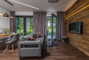 Moderní interiér pokoje v hotelu s dřevěným obložením a stylovým nábytkem.