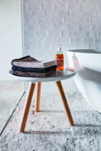 Detailní záběr na stoličku u volně stojící vany v moderní minimalistické koupelně.